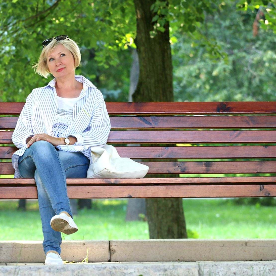 Kvinde sidder på en bænk og tænker.