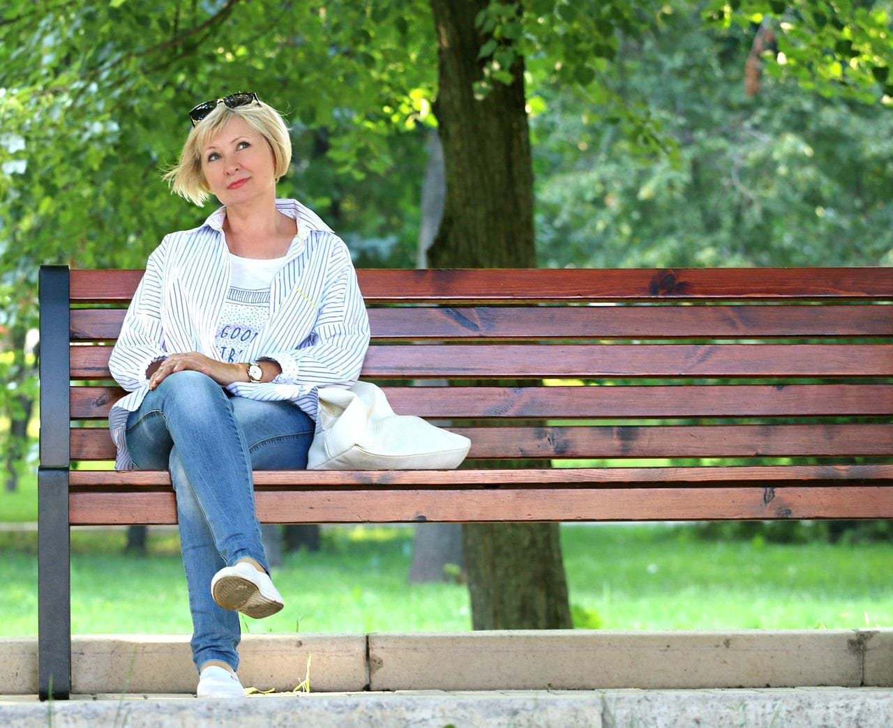 Kvinde sidder på en bænk og tænker.