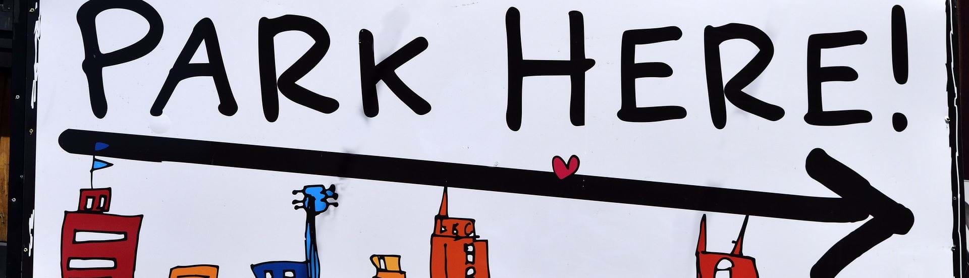 Et skilt med en illustraton af en storby med højhuse og skriften "park here!".