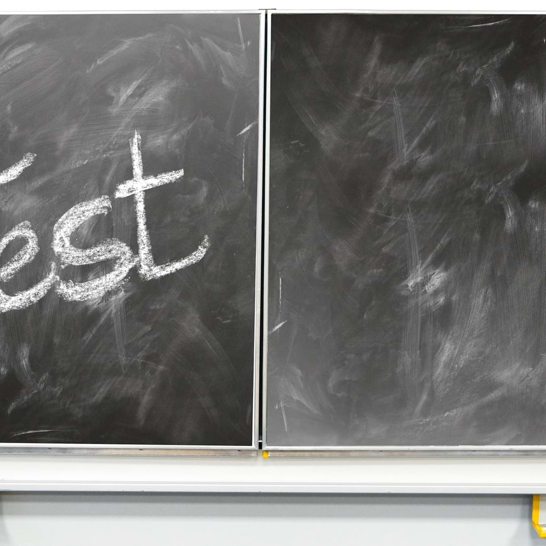 Skoletavle med ordet 'Test' skrevet med kridt