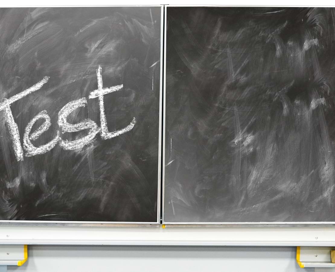 Skoletavle med ordet 'Test' skrevet med kridt