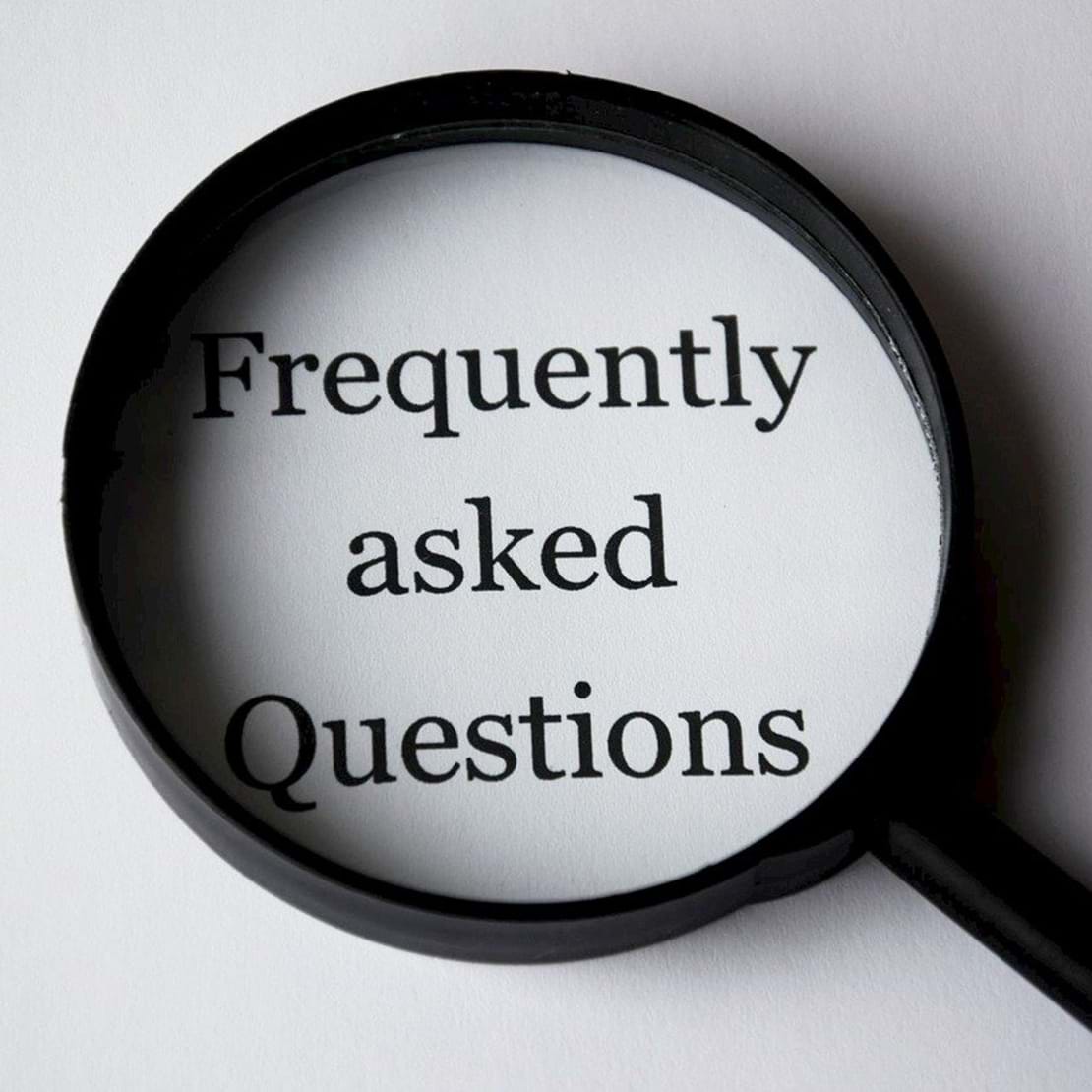 Billede af et forstørrelsesglas der forstørrer teksten 'Frequently asked questions'.