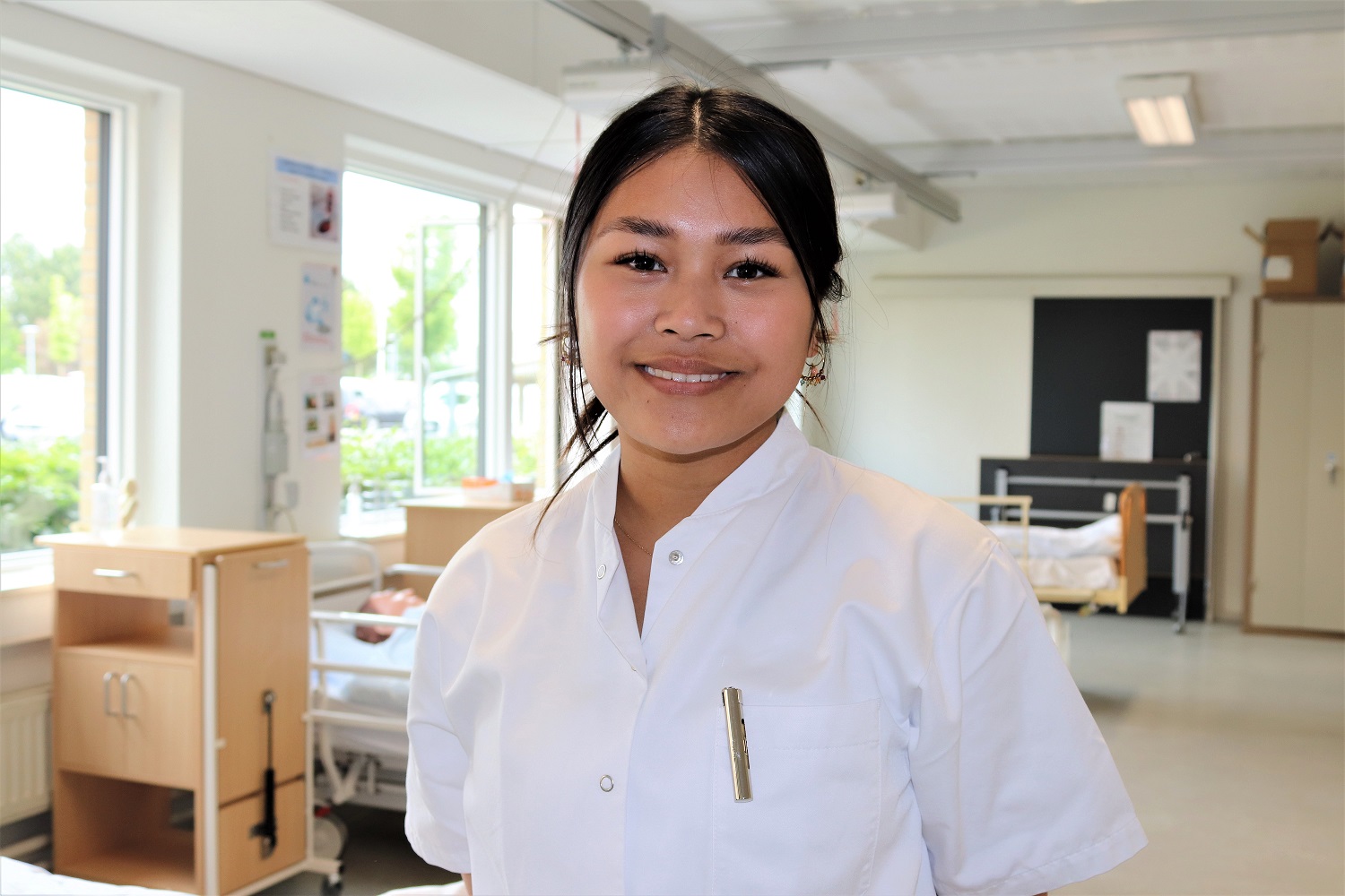 En unge pige i kittel smiler.