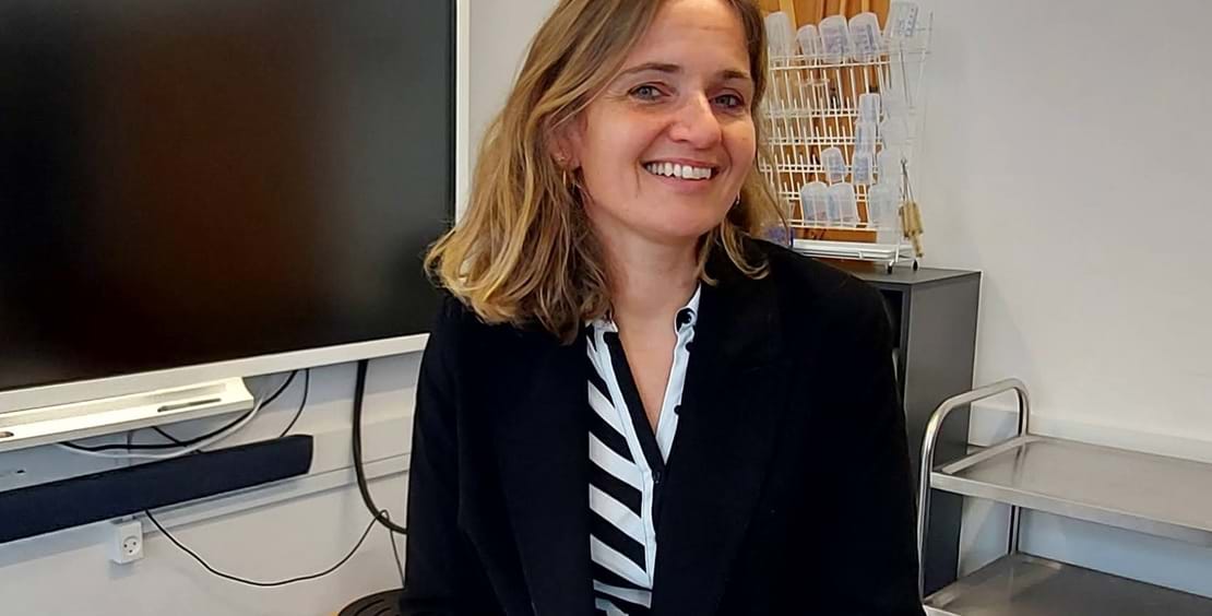 Mette Balstrup ser smilende ind i kameraet.