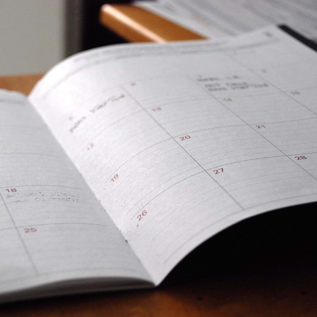En papirkalender ligger opslået på et bord.