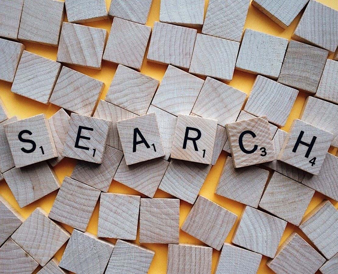 Scrabble-brikker danner ordet 'search' på en række