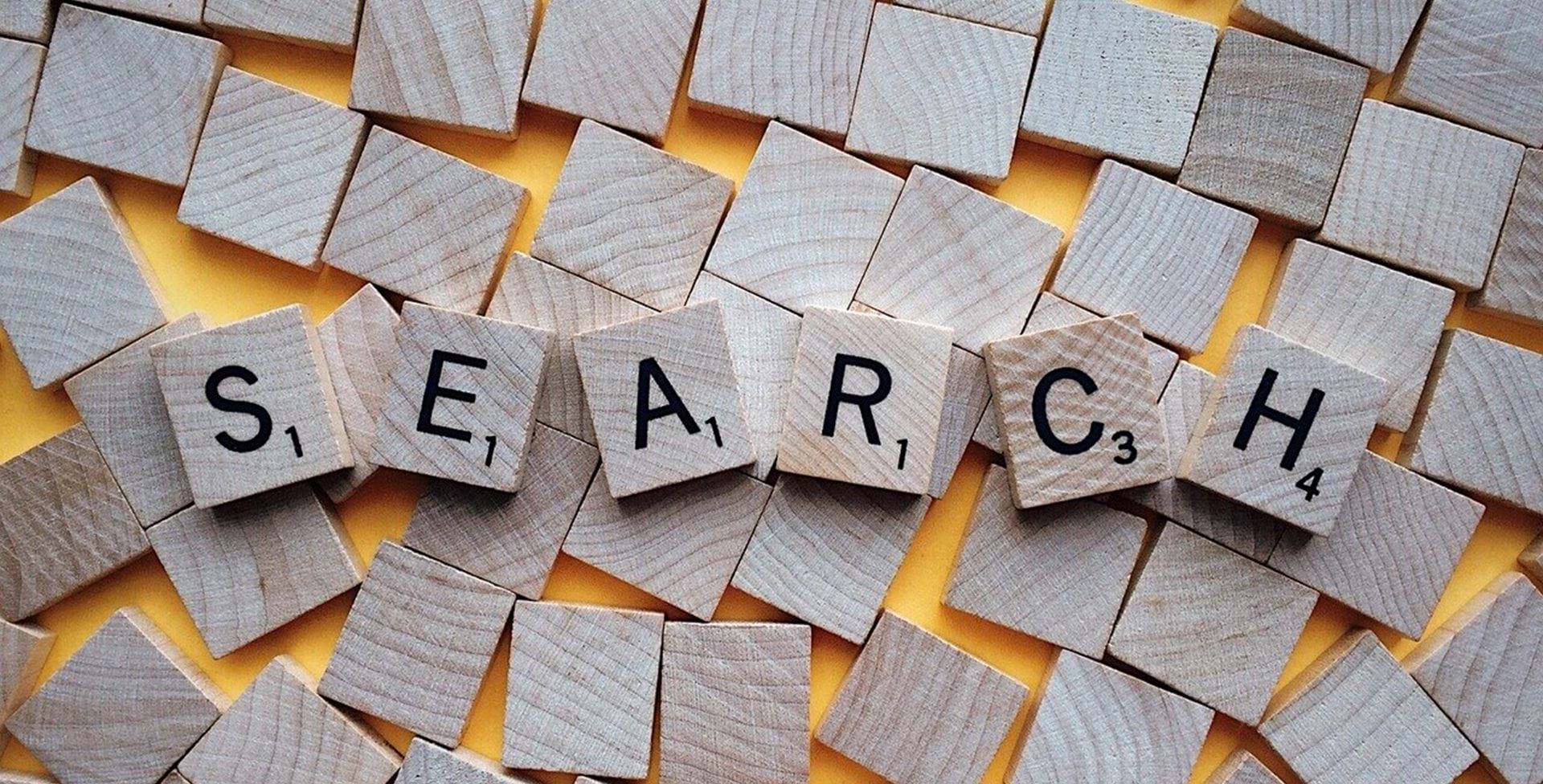 Scrabble-brikker danner ordet 'search' på en række